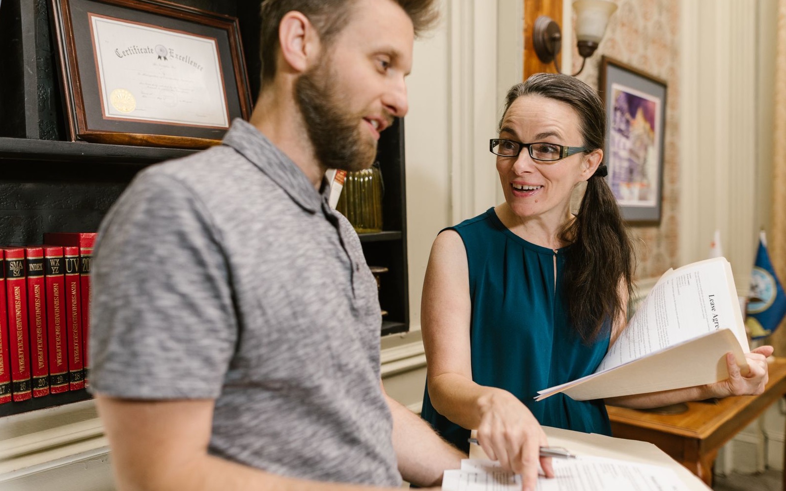 Two professionals discussing evidence in a book-lined office